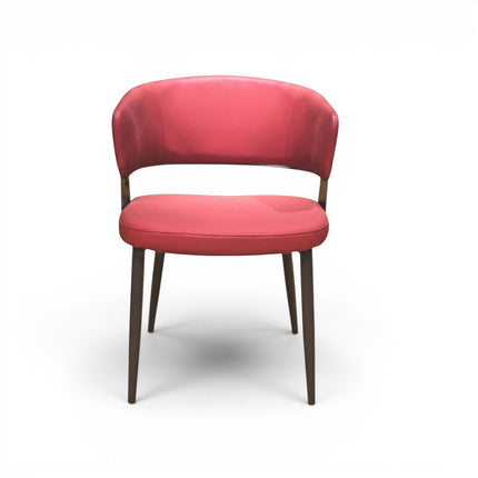 Gharnish modern dining chair in coral leather with stitched back and dark metal legs.